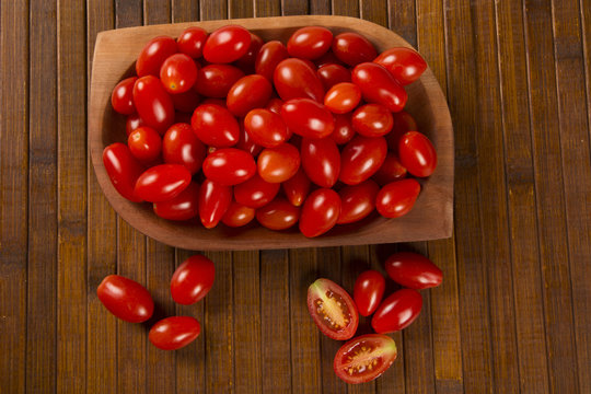A bowl of grape tomatoes over a wood table
