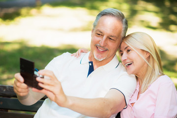 Mature couple taking a selfie in a park