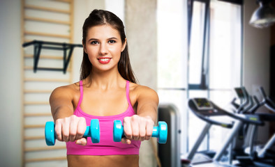 Fototapeta premium Yung woman working out in a gym