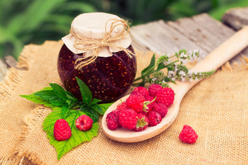 Fresh raspberries and jam on wooden table