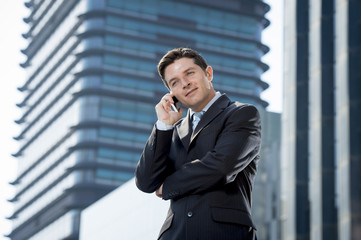 young attractive businessman talking on mobile phone happy outdoors