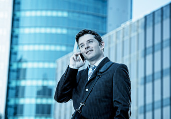 young attractive businessman talking on mobile phone happy outdoors