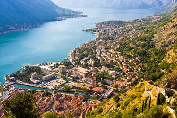 Looking over the Bay of Kotor in Montenegro with view of mountains, boats and old houses with red tile roofs