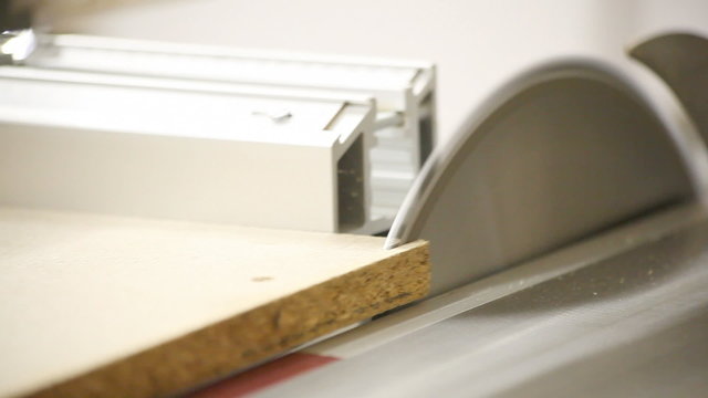 Circular table saw cutting wood in carpenter workshop