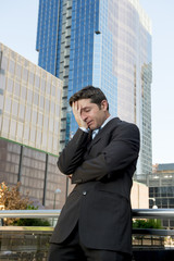 young exhausted and worried businessman standing outdoors in stress