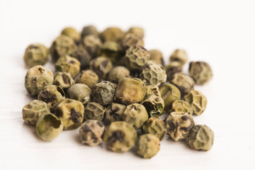 Green Peppercorns on wooden background
