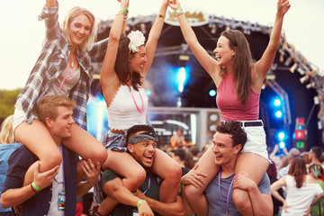 Friends having fun in the crowd at a music festival - obrazy, fototapety, plakaty
