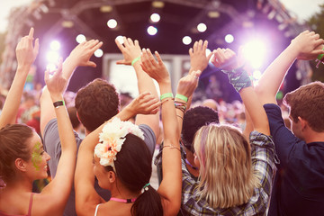 Audience with hands in the air at a music festival - obrazy, fototapety, plakaty