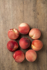Some peaches in a basket over a wooden surface