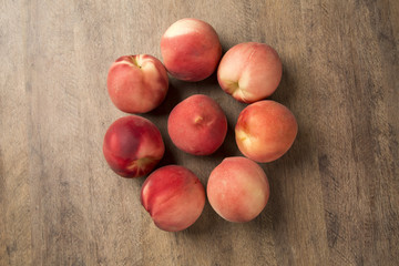 Some peaches in a basket over a wooden surface