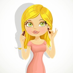 Cute blond girl colors eyelashes mascara isolated on a white bac