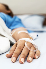 Focus on the hand of a patient in hospital ward