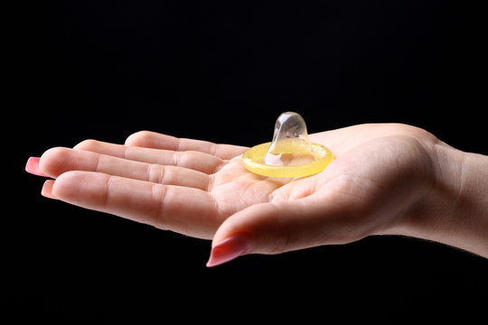 Yellow condom on the hand
