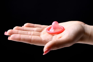 open red condom  on the hand