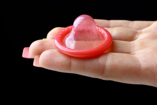 open red condom  on the hand