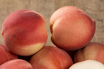 Some peaches in a basket over a wooden surface