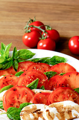 Tomaten - Mozarella Zubereitung - auf  einem Eichenholztisch