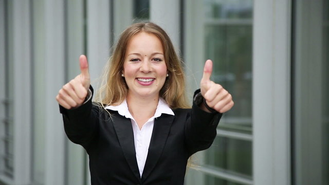 junge h&uuml;bsche blonde Gesch&auml;ftsfrau zeigt zwei Daumen hoch