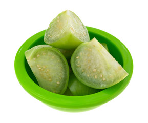 Cut tomatillos in a green dish