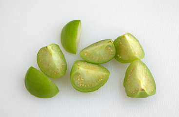 Cut tomatillos on a white cutting board