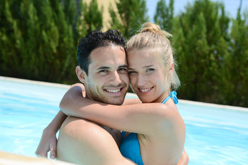 Fototapeta premium beautiful young couple in love playing together in a swimming pool