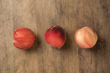 Some peaches in a basket over a wooden surface
