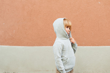 Fashion portrait of adorable toddler boy wearing grey sweatshirt