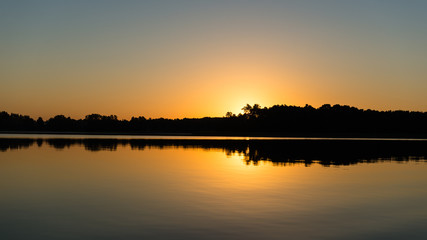 Fototapeta na wymiar symmetric reflections on calm lake