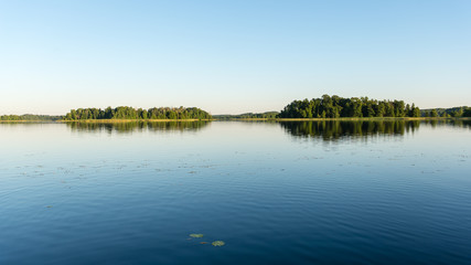 Fototapeta na wymiar symmetric reflections on calm lake