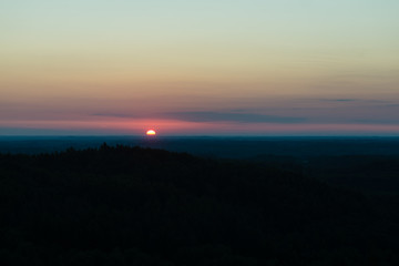 Dramatic sunrise over dark forest