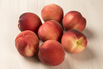 Some peaches in a basket over a white background
