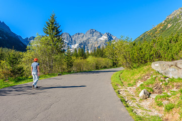 Young tourist walking on road to Morskie Oko lake in Tatra Mountains, Poland