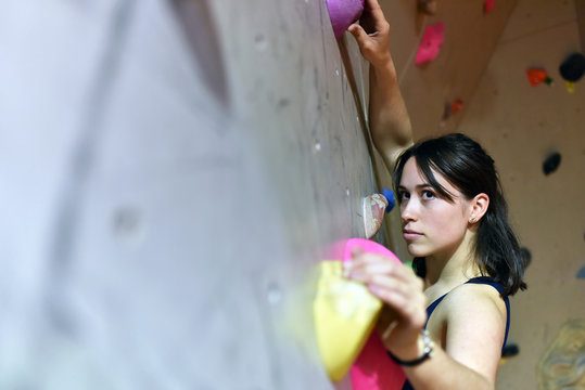 junge h&uuml;bsche Frau bouldert/ klettert indoor in einer Kletterhalle // climbing indoor 