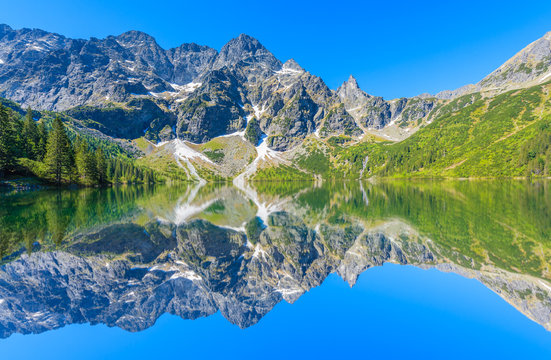 Reflection of mountain peaks in beautiful Morskie Oko lake, Tatra Mountains, Poland