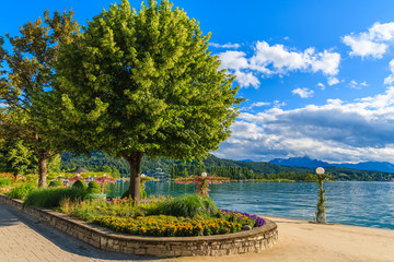 Promenade with flowers along Worthersee lake on beautiful summer day, Austria