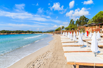 Sunchairs on famous white sand Palombaggia beach, Corsica island, France