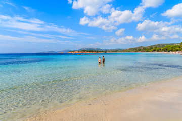 Couple of people in sea water on beautiful Palombaggia beach, Corsica island, France
