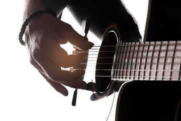 Acoustic guitar close-up with fingers playing it