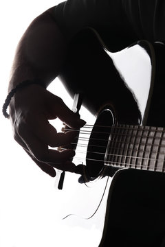 Acoustic guitar close-up with fingers playing it