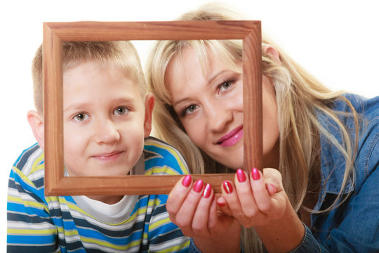 Portrait of mother and son holding photo frame