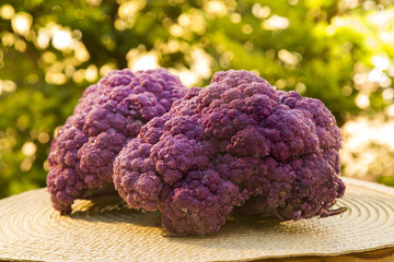 Some purple cauliflowers over a wooden surface seen from above