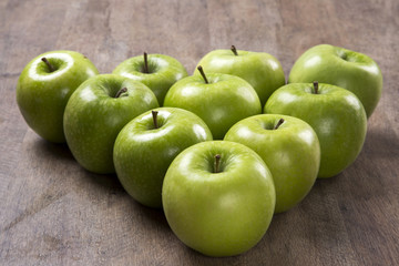 Some green apples on a wooden table