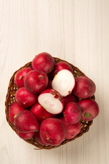 Some radishes in a basket over a white background