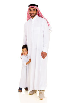 muslim man standing with his shy son