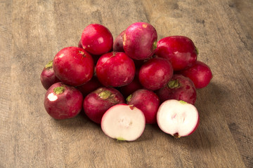 Some radishes in a basket over a wooden surface