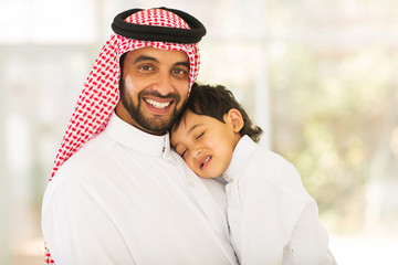 Arabian father holding his sleeping baby