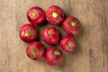 Some radishes in a basket over a wooden surface