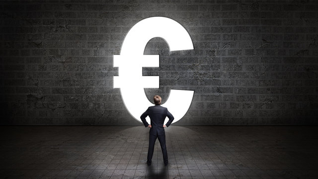 Geschäftsmann steht vor einem leuchtenden Euro-Durchgang 