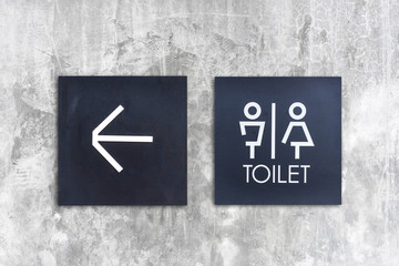 Unisex restroom or Toilet and arrow sign on  concrete wall style