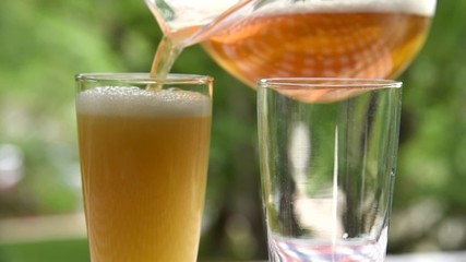 Pouring glasses of beer on a patio
